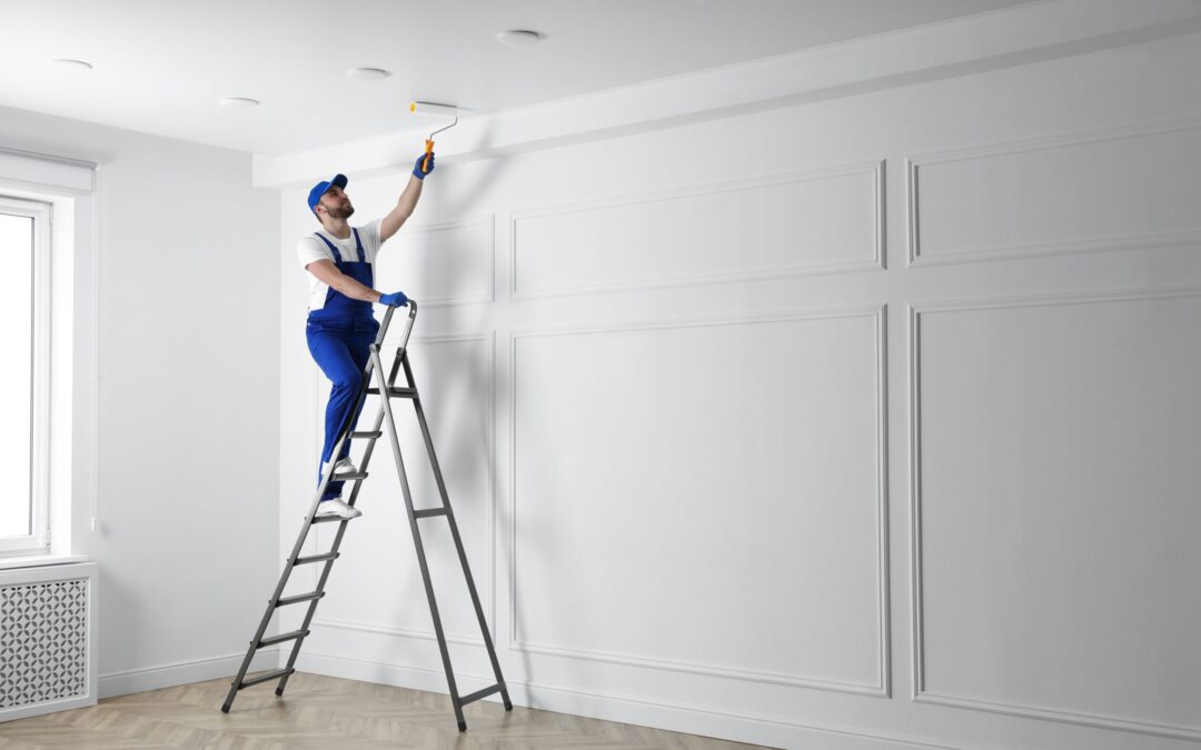 Handyman painting ceiling with white dye indoors, space for text